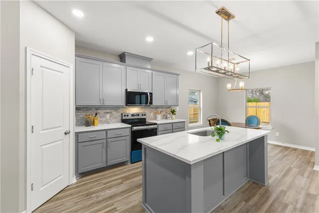 a kitchen with a sink stools a counter space and cabinets