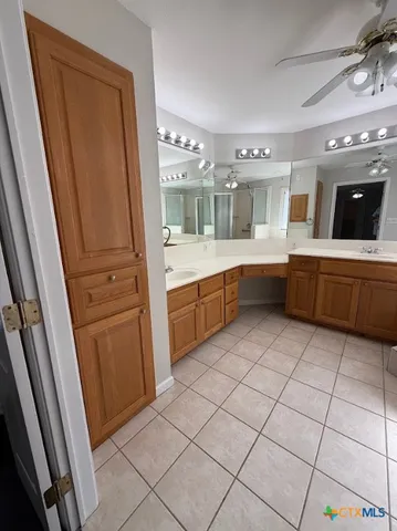 a large white kitchen with a sink a microwave and cabinets