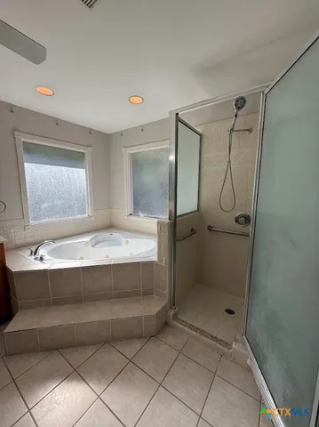 a bathroom with a tub a sink and mirror