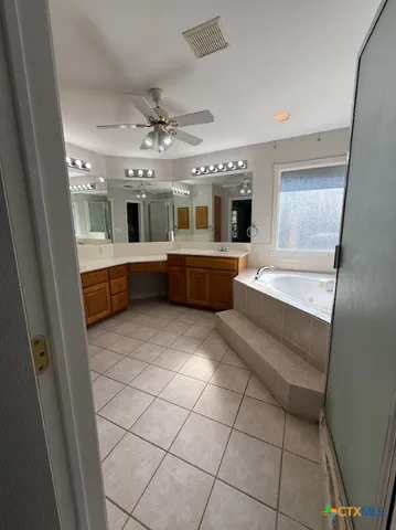 a large white kitchen with a large window and cabinets