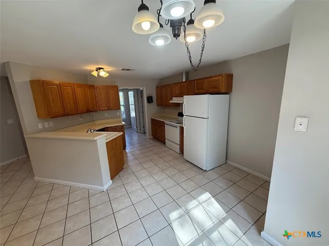 a kitchen with a refrigerator sink and cabinets