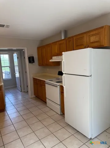 a kitchen with a refrigerator sink and cabinets