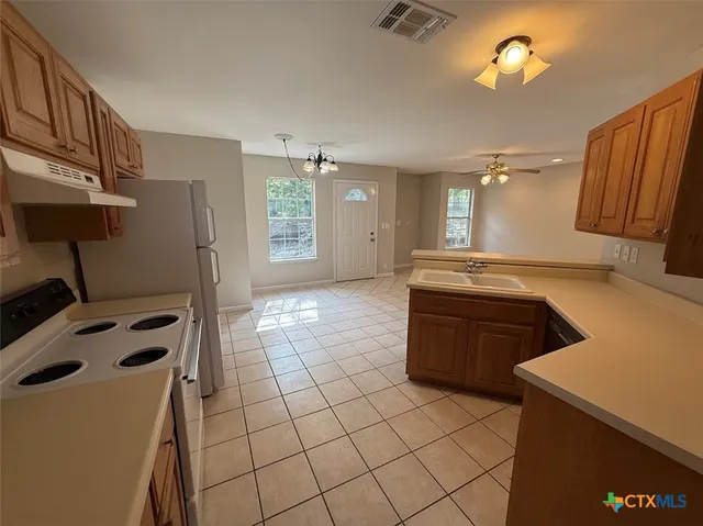 a kitchen with a sink a stove and cabinets