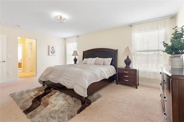 a bedroom with a bed and a dresser next to a window