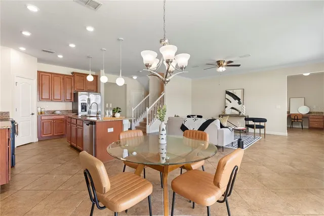 a dining room filled chandelier and kitchen view