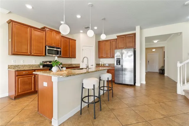 a kitchen with stainless steel appliances granite countertop a refrigerator a stove top oven a sink dishwasher and a refrigerator with a cabinets