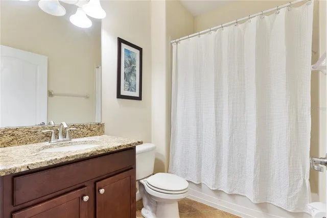 a bathroom with a granite countertop sink toilet and a mirror