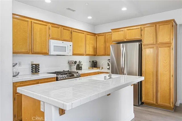 a kitchen with stainless steel appliances granite countertop a sink refrigerator and cabinets