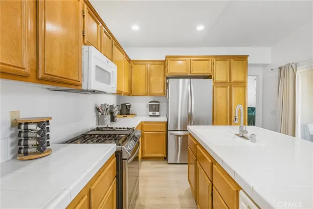 a kitchen with stainless steel appliances granite countertop a sink a stove and a refrigerator