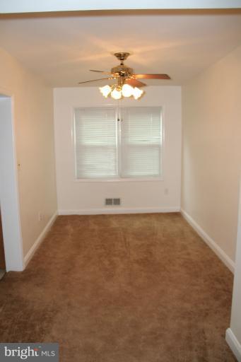 2211 Hawthorne Road Baltimore, MD 21220 - Photo 8 of 10 an empty room with a window and a chandelier fan