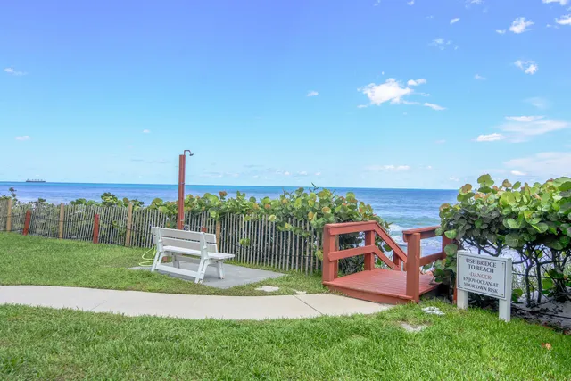 a view of a garden with a bench in front of the house