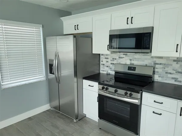 a kitchen with stainless steel appliances a stove a microwave and a sink