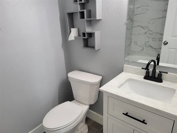 a bathroom with a sink a toilet and a mirror
