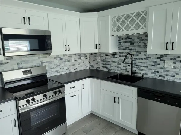 a kitchen with stainless steel appliances a stove a sink and a microwave