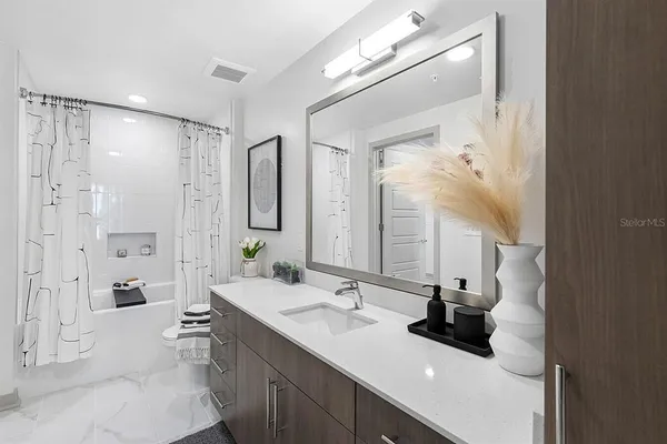 a bathroom with a double vanity sink mirror and shower