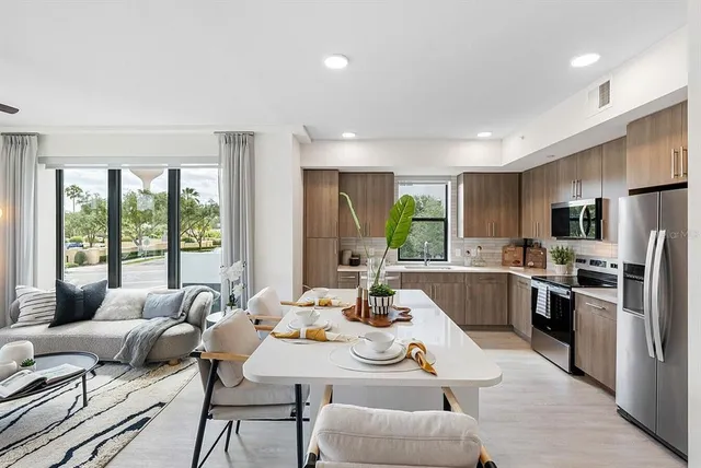 a dining room with furniture a large window and kitchen view