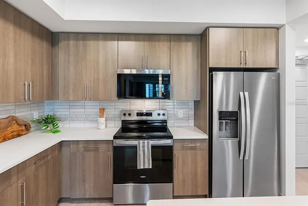 a kitchen with a refrigerator a microwave a sink and cabinets