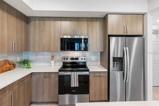 a kitchen with a refrigerator a microwave a sink and cabinets