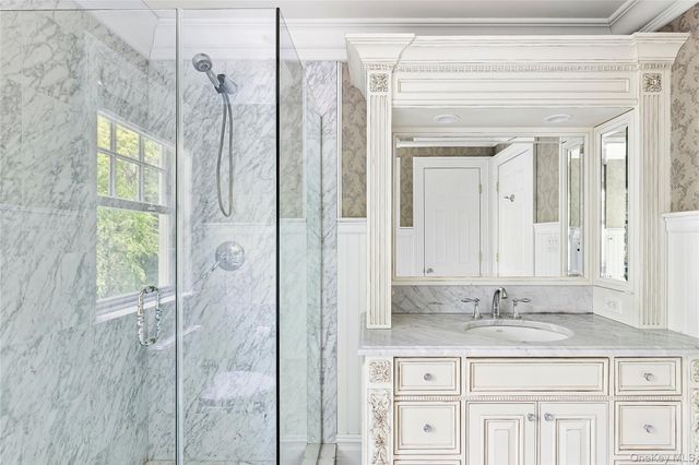 a bathroom with a granite countertop sink a mirror and a shower