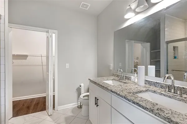 a bathroom with a granite countertop sink toilet and shower