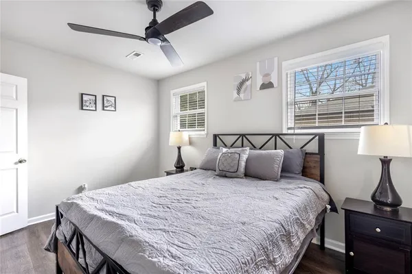 a bedroom with a large bed and a lamp on dresser