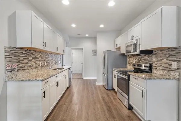 a kitchen with stainless steel appliances granite countertop a stove a sink and a refrigerator