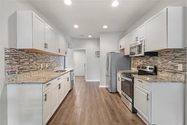 a kitchen with stainless steel appliances granite countertop a sink stove and refrigerator