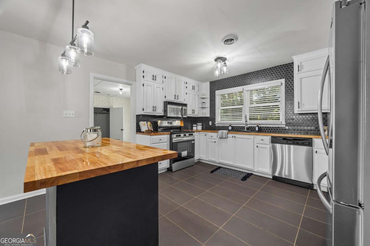 110 Valley Road Toccoa, GA 30577 - Photo 14 of 39 a kitchen with stainless steel appliances a sink a stove a refrigerator cabinets and a window