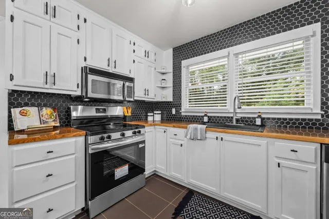 a kitchen with granite countertop a sink a stove and cabinets