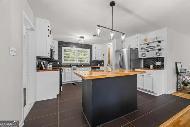 a kitchen with stainless steel appliances granite countertop a sink a stove and a refrigerator