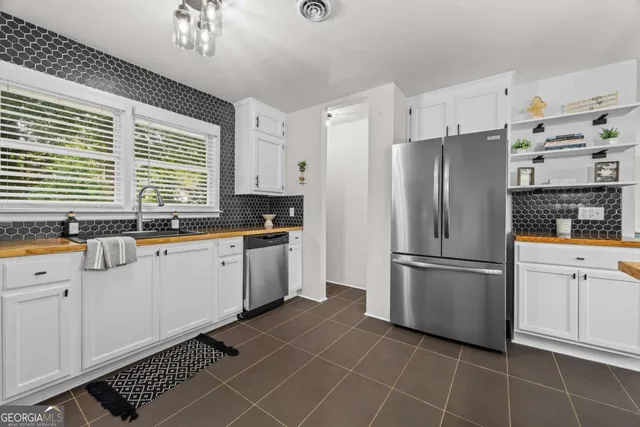 a kitchen with stainless steel appliances a refrigerator sink and cabinets