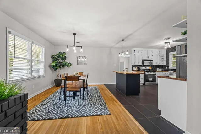 a dining room with furniture a chandelier and wooden floor