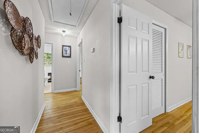 a view of a hallway with wooden floor and entryway
