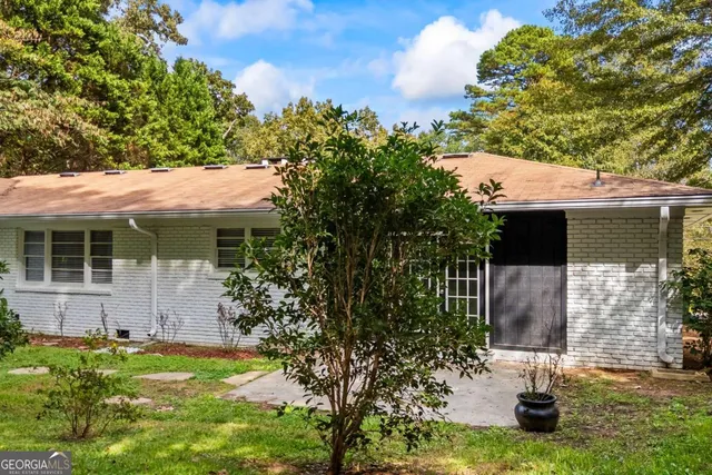 a view of a house with backyard and sitting area