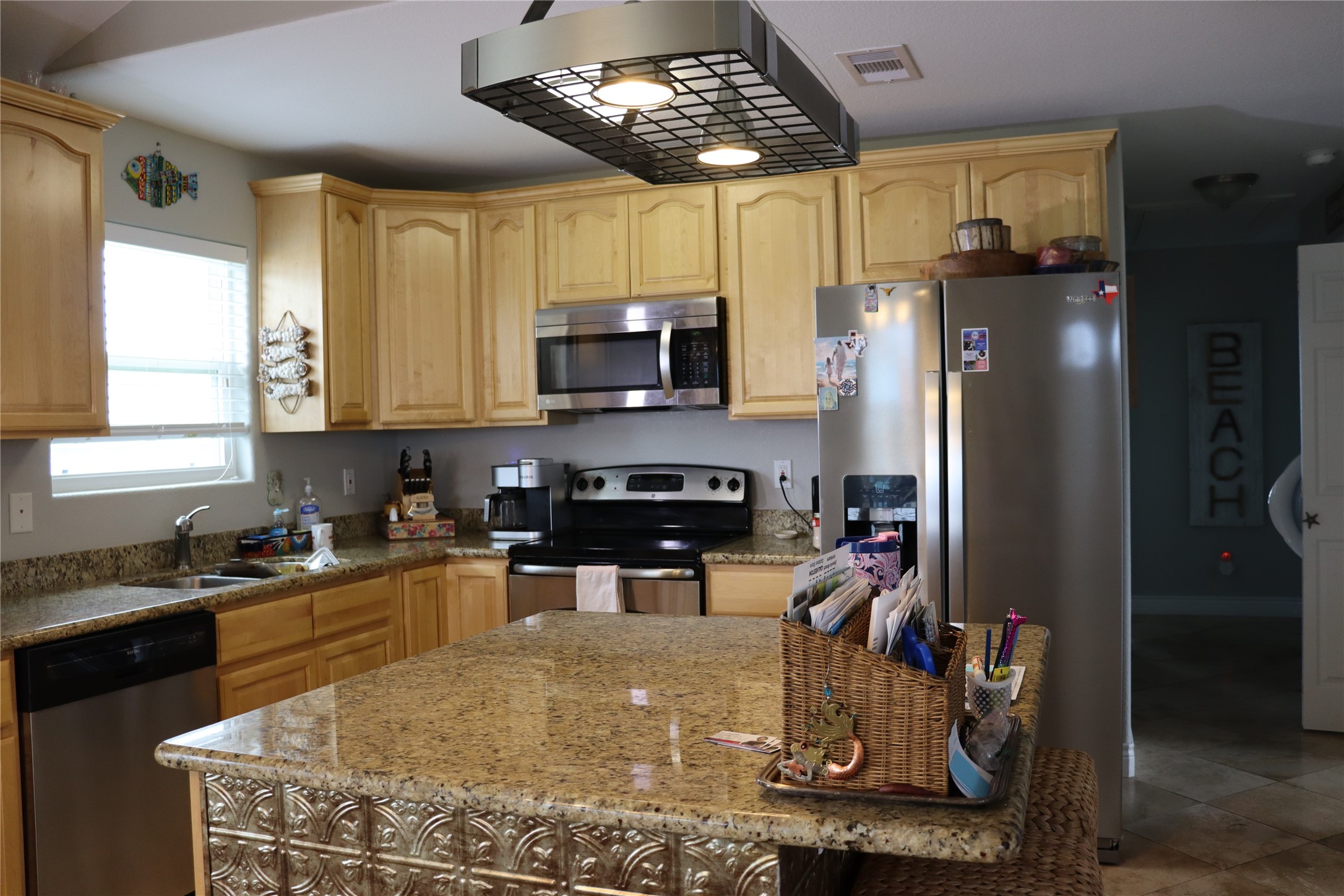 4123 Reeves Drive Galveston, TX 77554 - Photo 6 of 28 a kitchen with stainless steel appliances granite countertop a sink a stove and a refrigerator