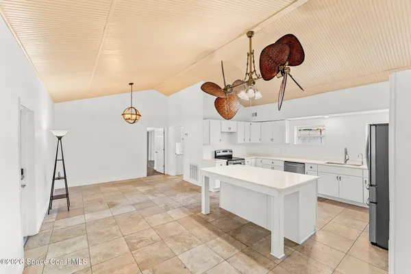 a kitchen with a sink a stove and chairs