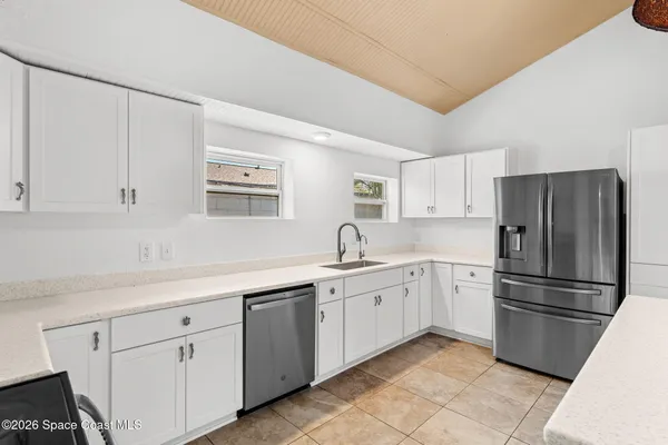 a kitchen with a refrigerator sink and cabinets