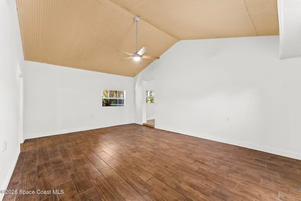 a view of empty room with wooden floor
