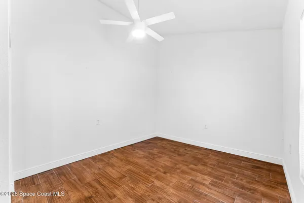 an empty room with wooden floor and window