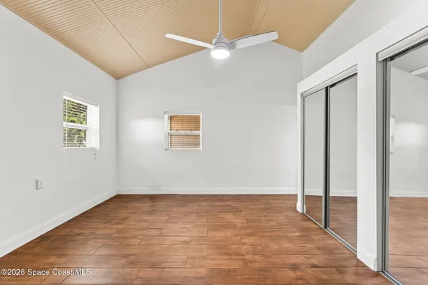 a view of empty room with wooden floor