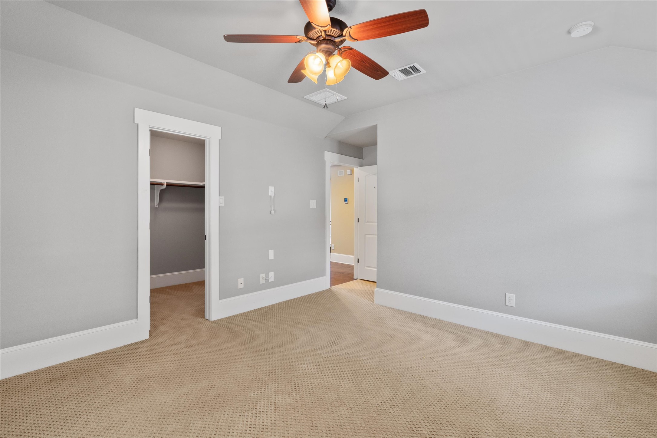 8417 Etienne Cove Austin, TX 78759 - Photo 27 of 35 Comfortable carpeted bedroom features a ceiling fan, closet, and ample space for rest and relaxation.