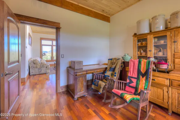 a living room with furniture large window and wooden floor