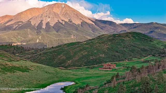 a view of a house with a big yard and large trees