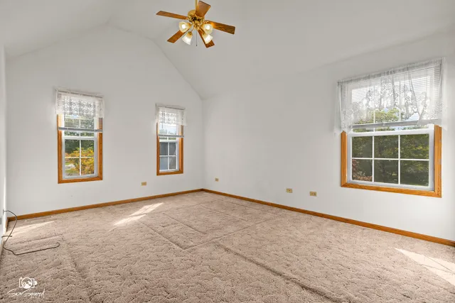 an empty room with closet and windows