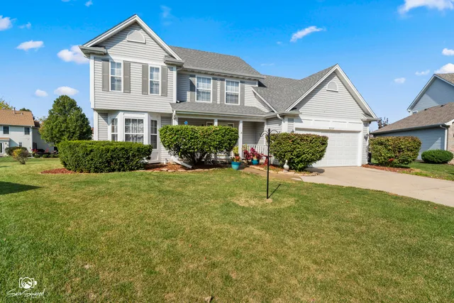 a front view of a house with a yard and potted plants