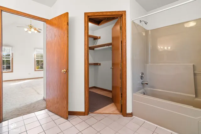 a view of an empty room with wooden floor and windows