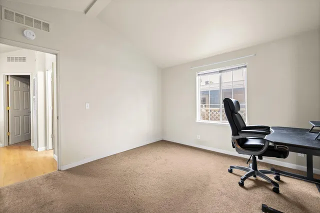 a view of a workspace with furniture and a window