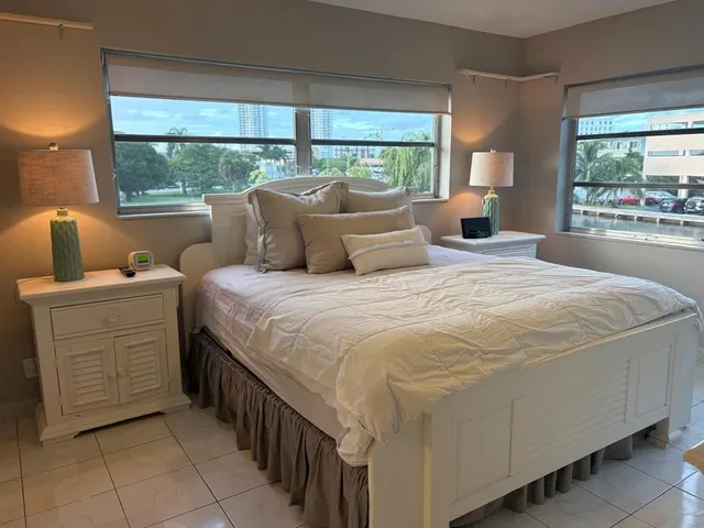 a bedroom with a bed and large windows