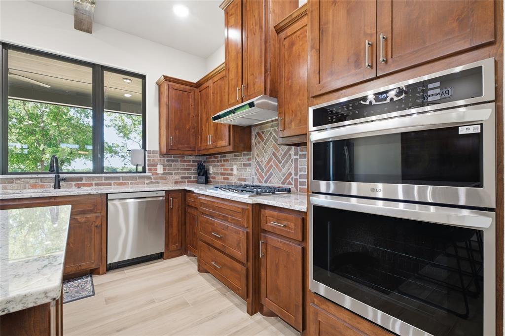 958 Cedar Mills Road Gordonville, TX 76245 - Photo 8 of 40 a kitchen with stainless steel appliances granite countertop a stove microwave and sink