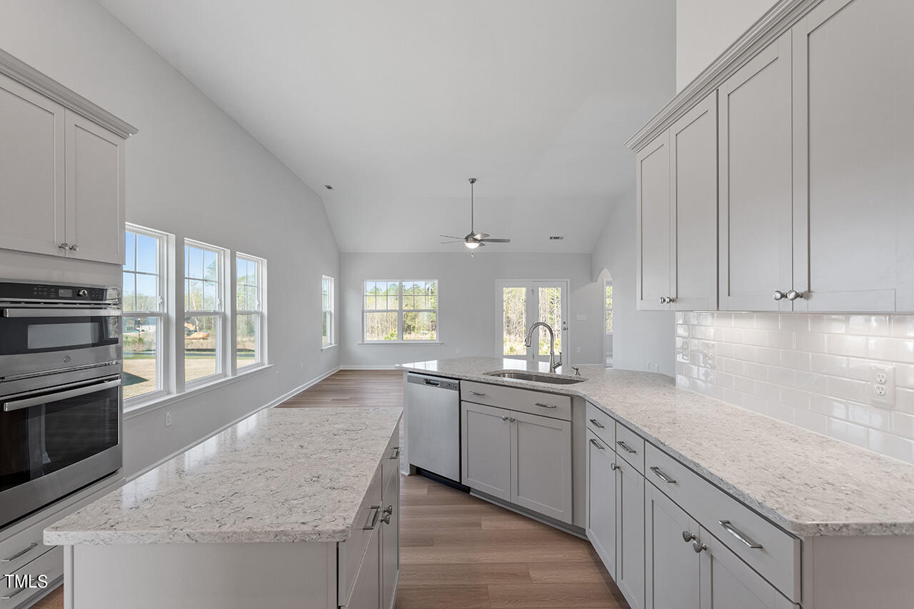 63 Beech Tree Way, Unit 139 Garner, NC 27529 - Photo 11 of 25 a kitchen with granite countertop a sink stove and cabinets
